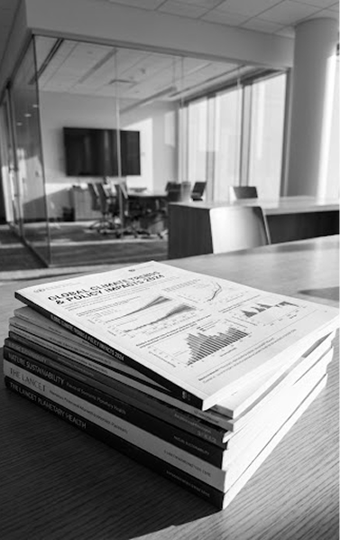 Grayscale photograph of a stack of academic journals on a desk